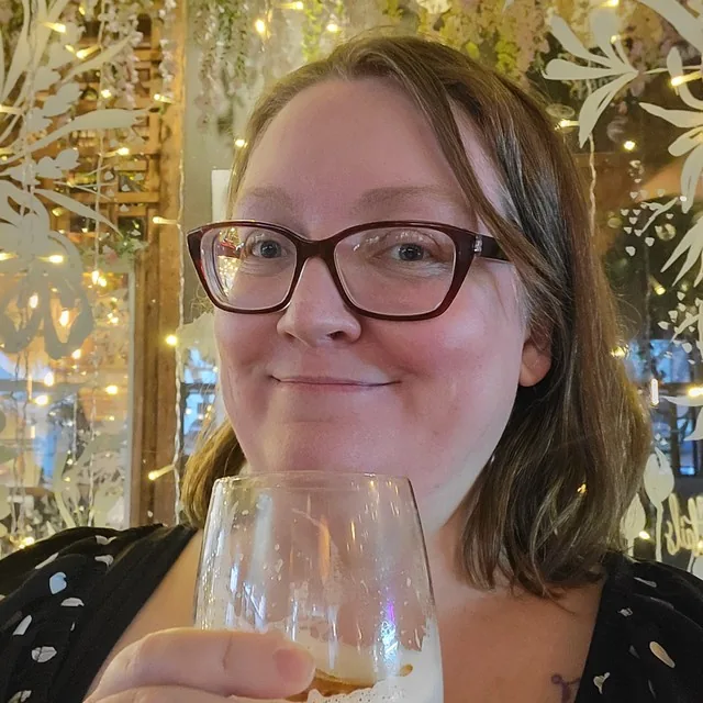 Su Hardy, smiling, in glasses